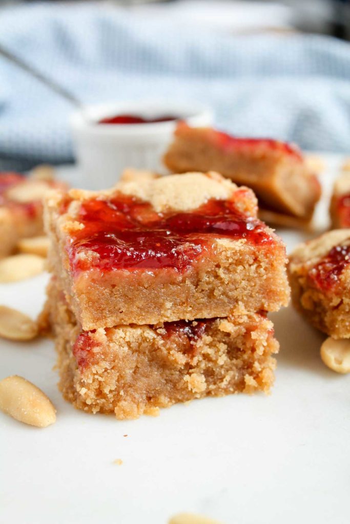 Two stacked peanut butter bars with a strawberry jam swirl on top