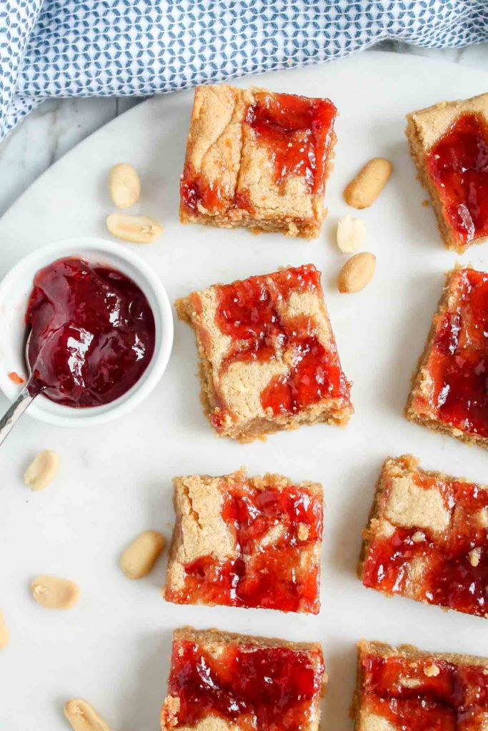 A few peanut butter and jelly bars on a white plate.