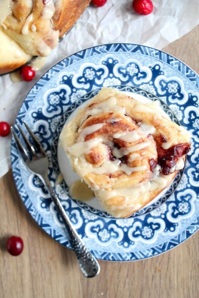 a glazed sweet roll with cranberry filling on a plate