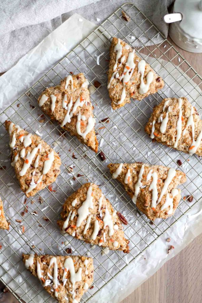 overhead view of several glazed scones on a wire rack set over parchment paper