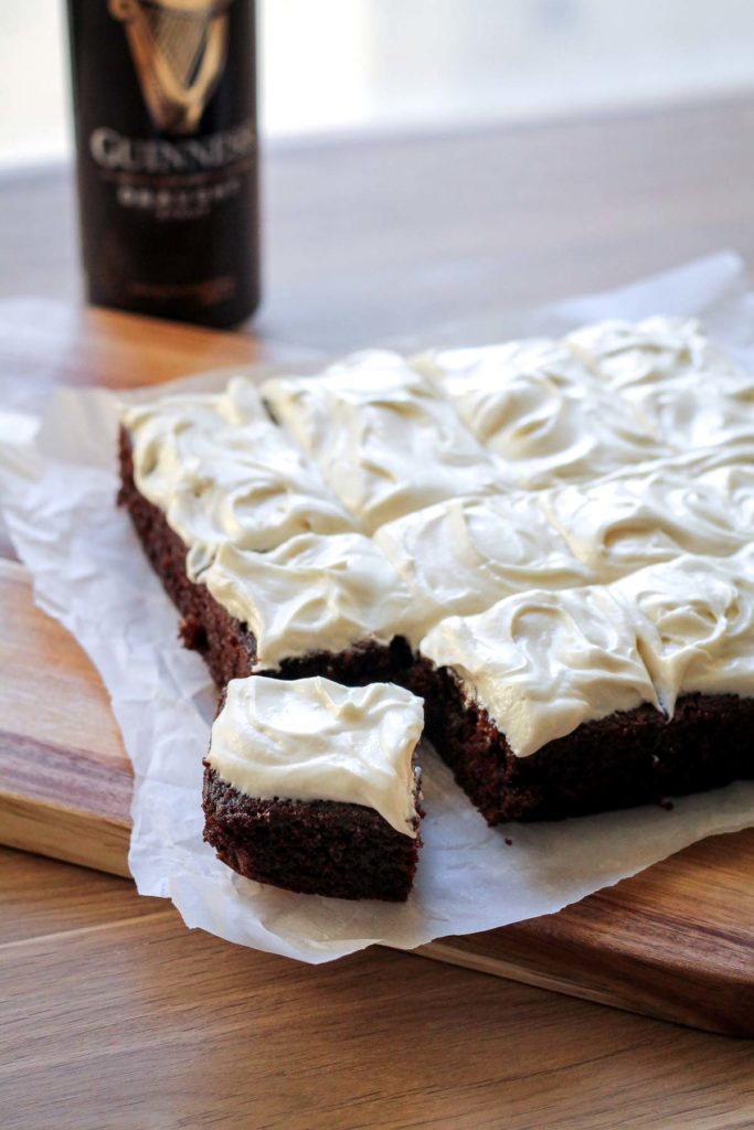 A finished slice of chocolate guinness cake with irish cream frosting on a cutting board.