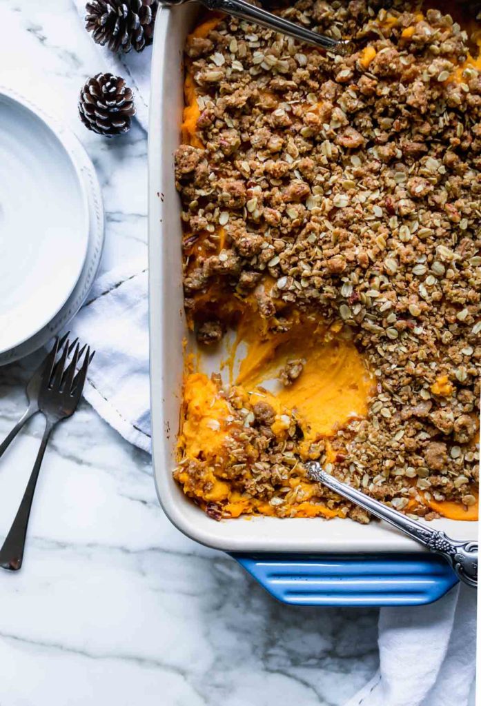 A pan of lighter Sweet Potato Casserole (No Eggs) with serving spoons