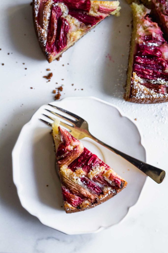 one slice of cake on a white plate with a fork next to it