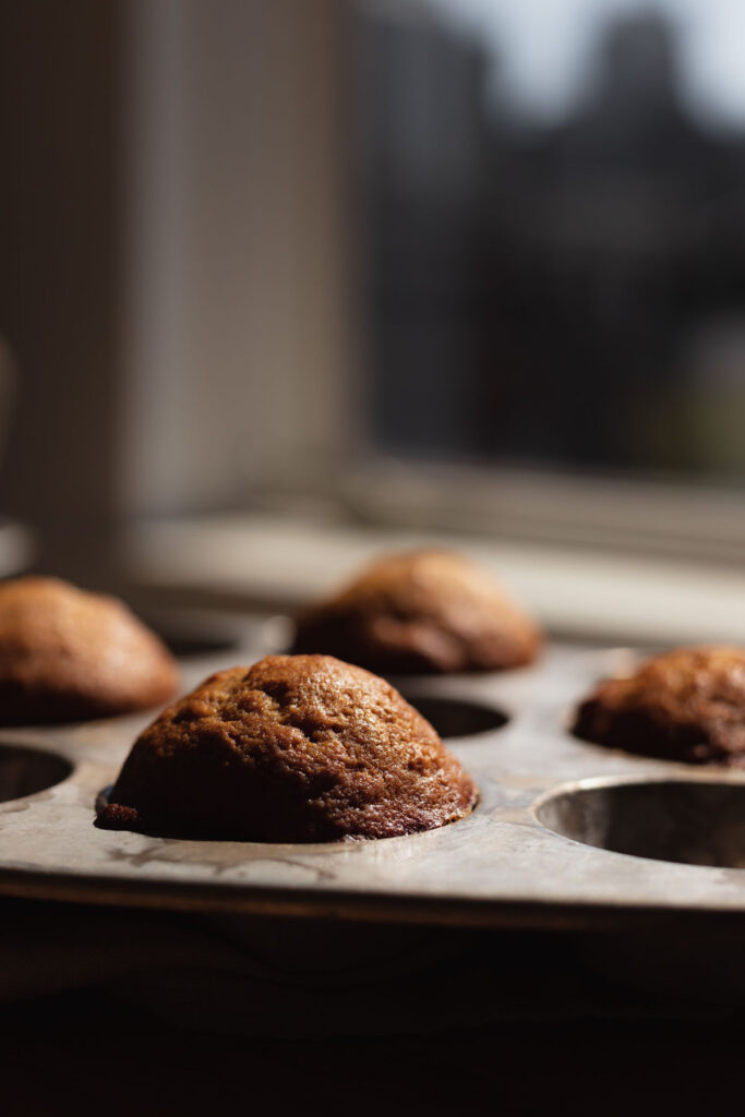 Tall muffin tops in front of a window