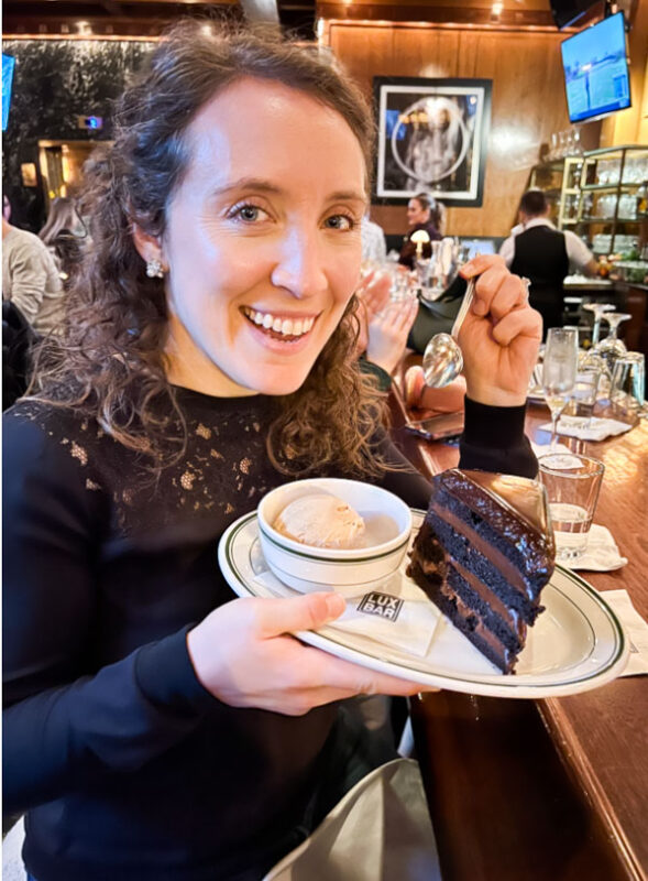 Profile photo of Katie holding a piece of chocolate cake