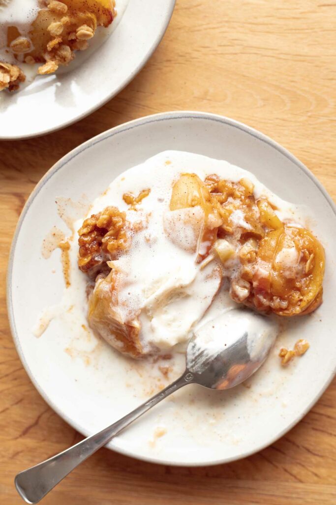 A bowl of the easiest apple crisp with oat topping and vanilla ice cream