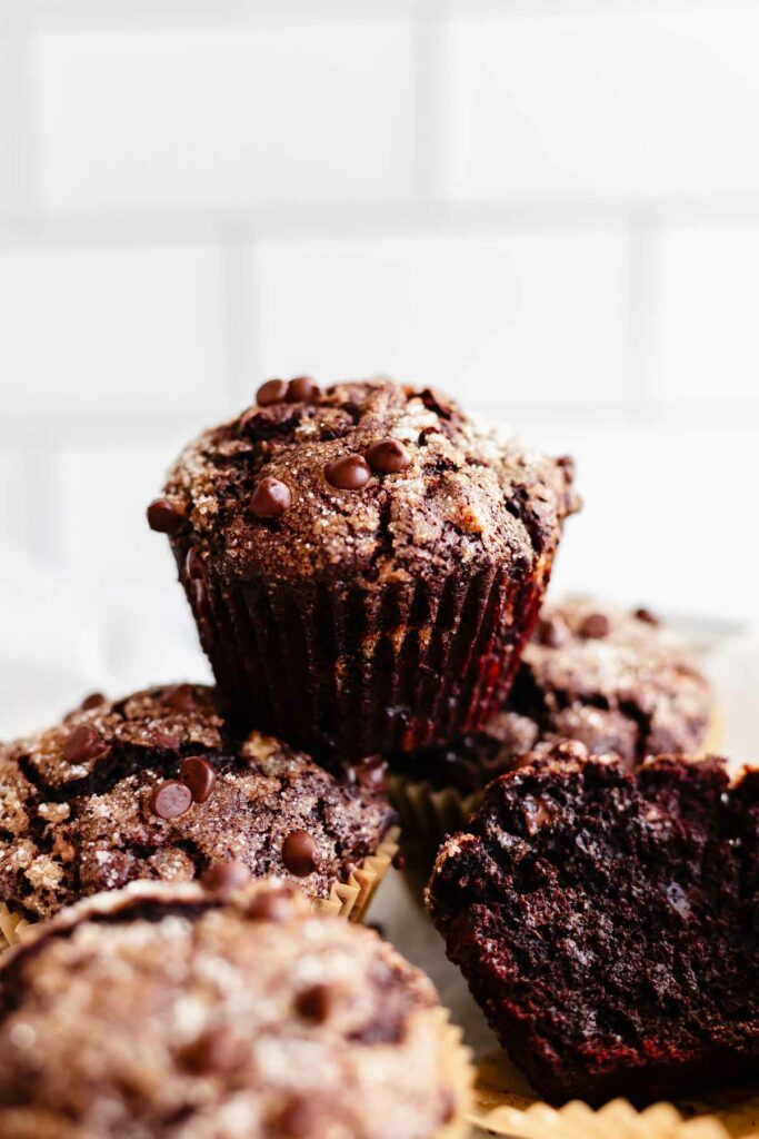 a stack of double chocolate banana muffins against a white kitchen background