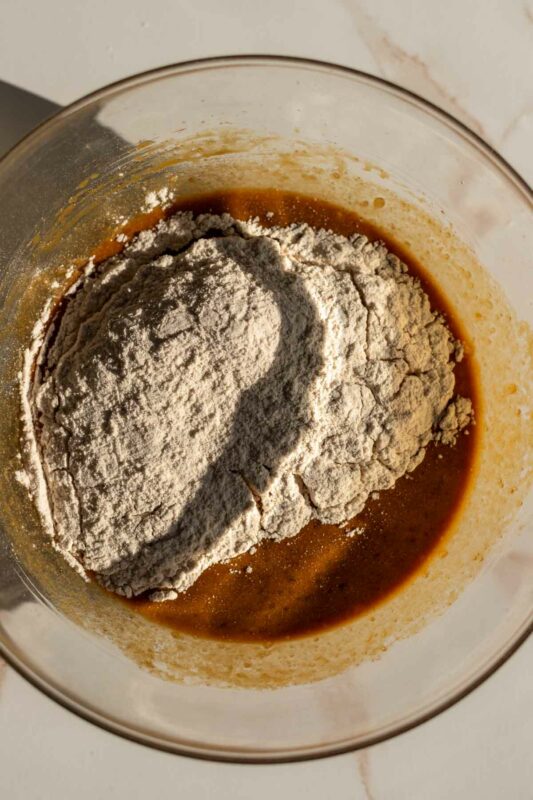 warming gingerbread spices mixed into flour, dumped in a bowl with the wet ingredients for the batter
