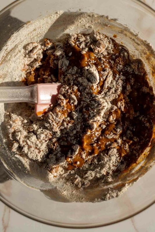 muffin batter mid-stirring with flour pockets visible