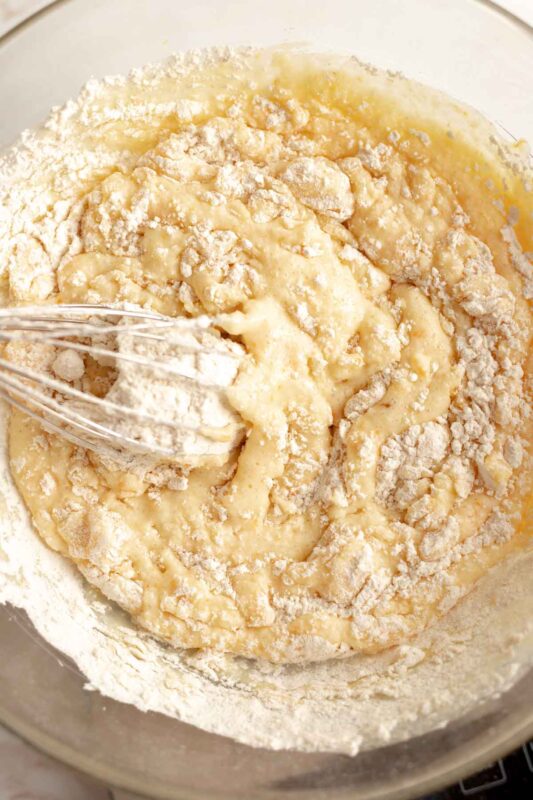 mixing the dry ingredients into the muffin batter with a whisk